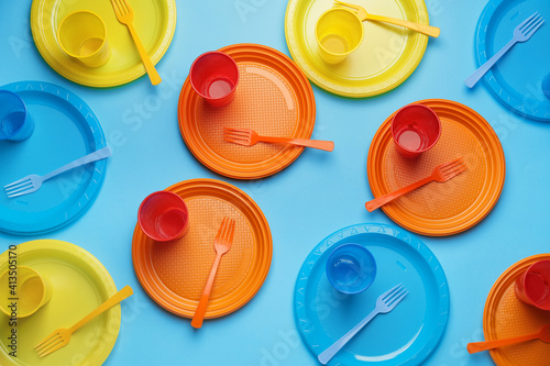 Plastic tableware on color background photo