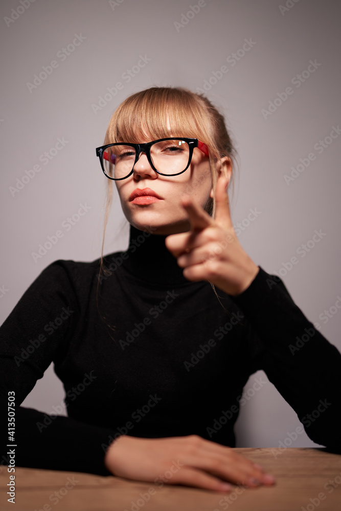 I'm choosing you. The smiling portrait of a woman making pointing you gesture on gray studio background. The human emotions, facial expression concept. Front view photo