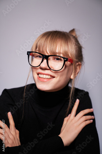 Fototapeta Naklejka Na Ścianę i Meble -  Portrait of sensual blonde woman wears trendy pink and black glasses. Indoor studio photo of girl wearing black sweater