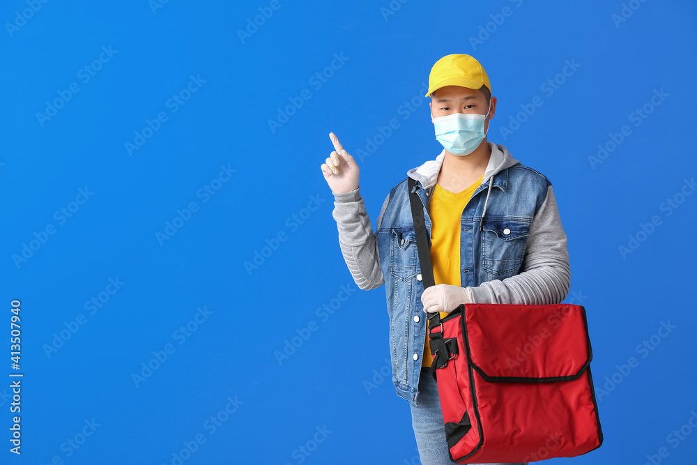 Courier of food delivery service pointing at something on color background Courier of food delivery service pointing at something on color background