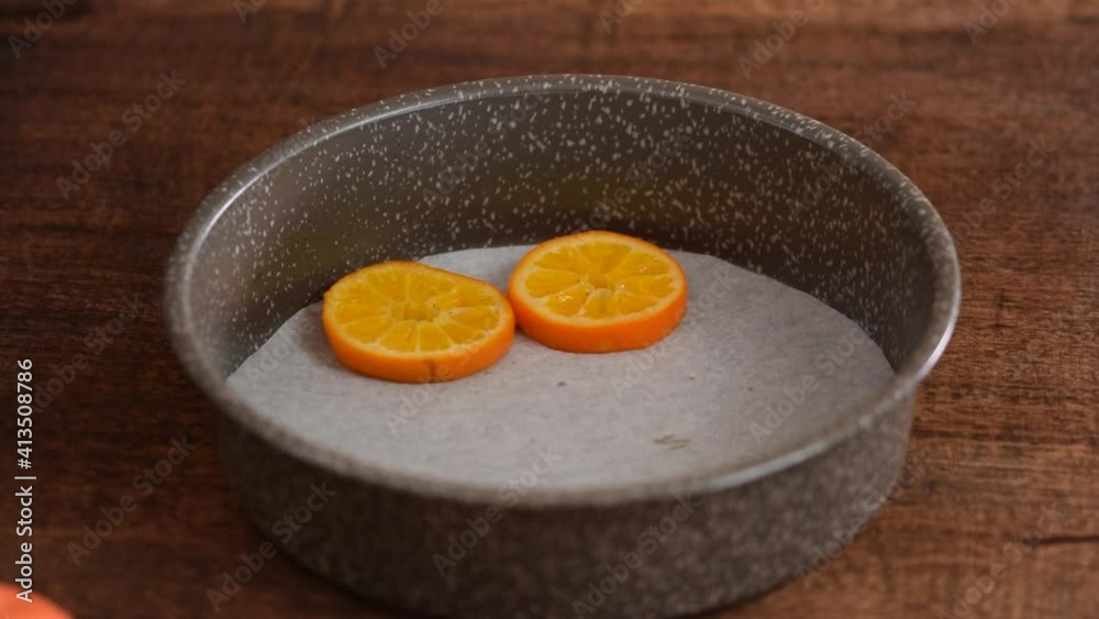 Woman cooking a tangerines cake in the kitchen.