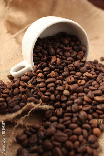 variety of roasted arabica and robusta coffee beans from Indonesia, pouring from a cup