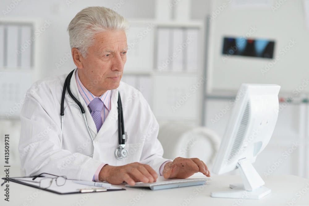 Portrait of senior male doctor working with laptop Portrait of senior male doctor working with laptop