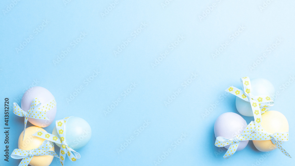 Easter eggs isolated. Colorful egg with tape ribbon on pastel blue background in Happy Easter decoration. Flat lay, top view.