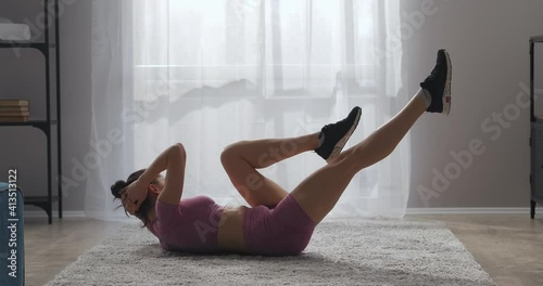 sportswoman is training in home, doing exercises for slenderness and good body shape, fitness and bodybuilding