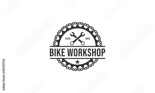 logo for bicycle repair shop with illustration of bicycle gear and repair tools