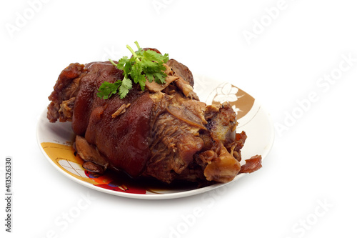 Traditional Bavarian schweinshaxe with coleslaw and preztel as closeup on a white background