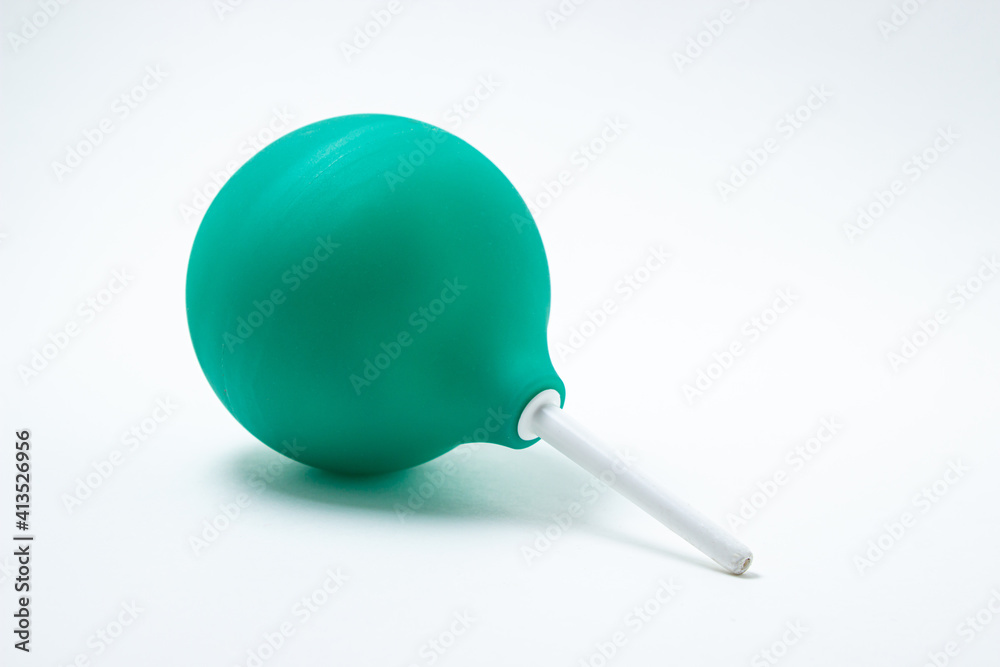 Green enema on a white background. Constipation treatment. Home treatment Green enema on a white background. Constipation treatment. Home treatment
