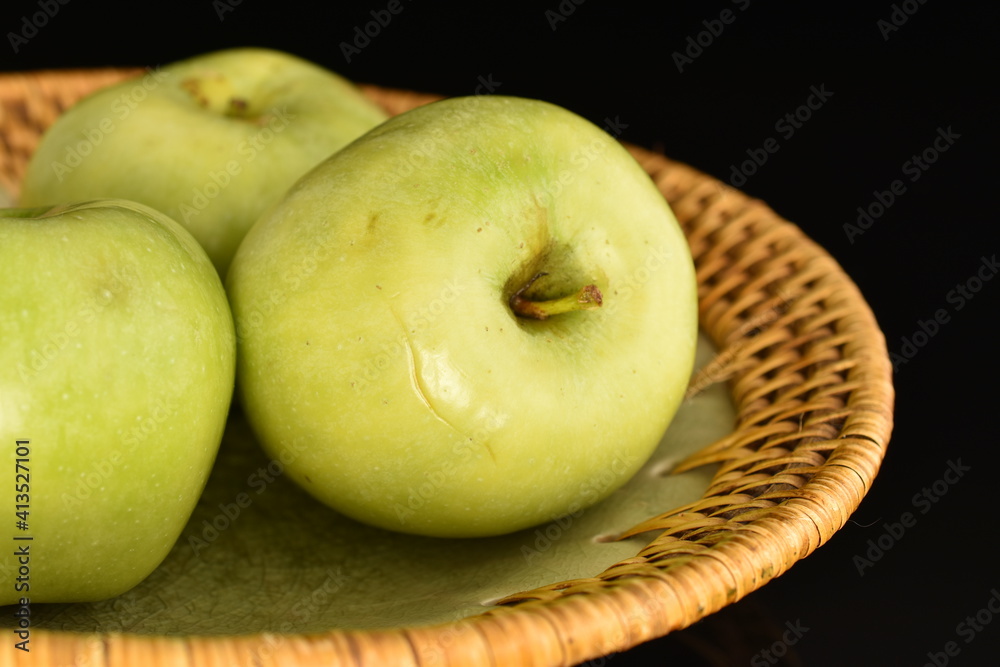 Several natural green apples by Renet Simirenko with a ceramic plate, close-up, isolated on black. Several natural green apples by Renet Simirenko with a ceramic plate, close-up, isolated on black.