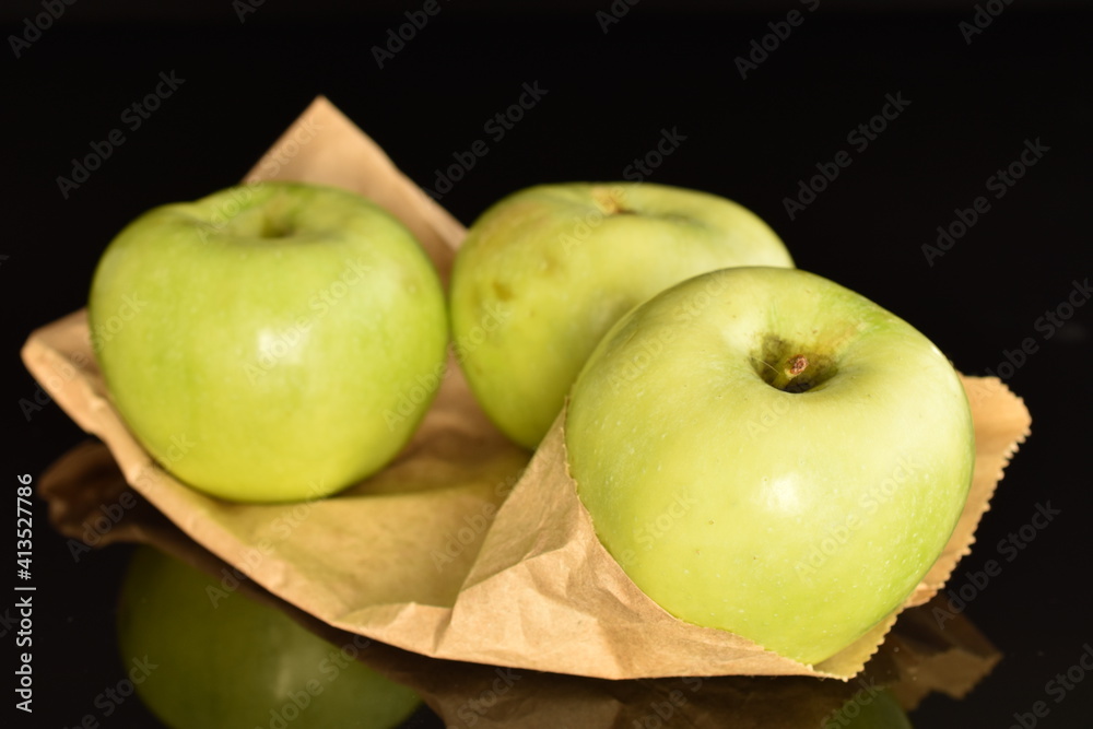 Three natural green apples by Renet Simirenko with a paper bag, close-up, isolated on black. Three natural green apples by Renet Simirenko with a paper bag, close-up, isolated on black.