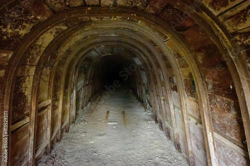 Dark underground tunnel with wooden walls in abandoned mine 