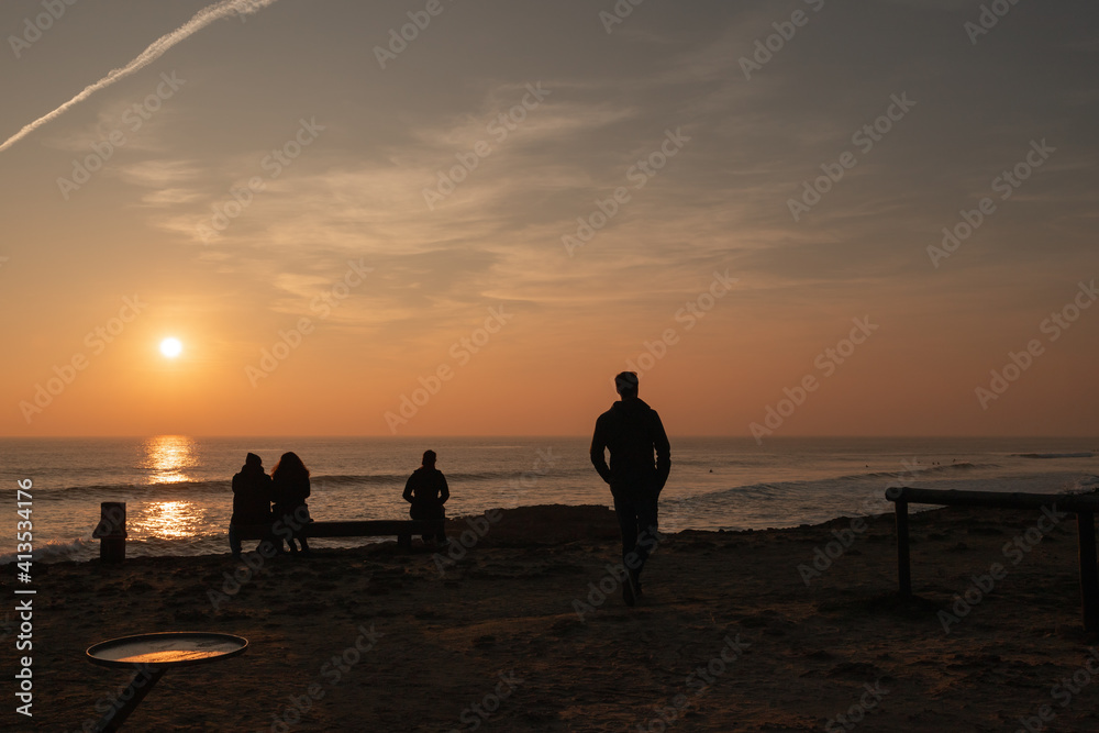 Man walking at sunset in the Atlantic ocean in Portugal
