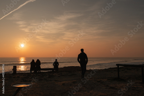 Man walking at sunset in the Atlantic ocean in Portugal