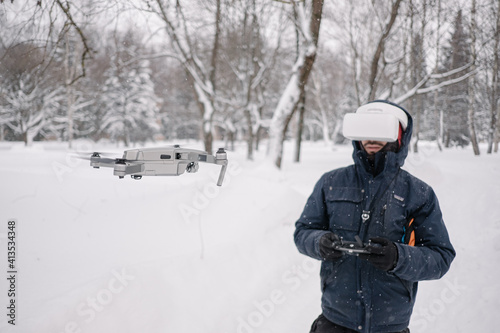 Man in Virtual reality glasses and controller controlling a drone. Drone flying. Modern technology