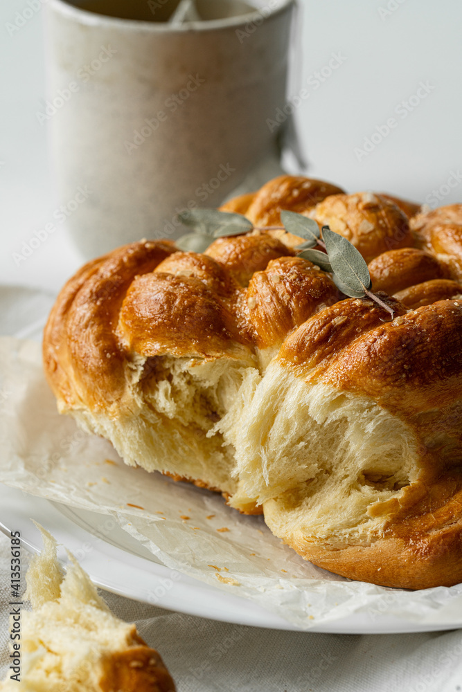 Freshly baked homemade braided brioche and cup of tea on white background. Freshly baked homemade braided brioche and cup of tea on white background.
