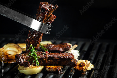 grilled barbecue ribs pork with rosemary. ribs with barbecue sauce. American cuisine. Food recipe background. Close up. place for text