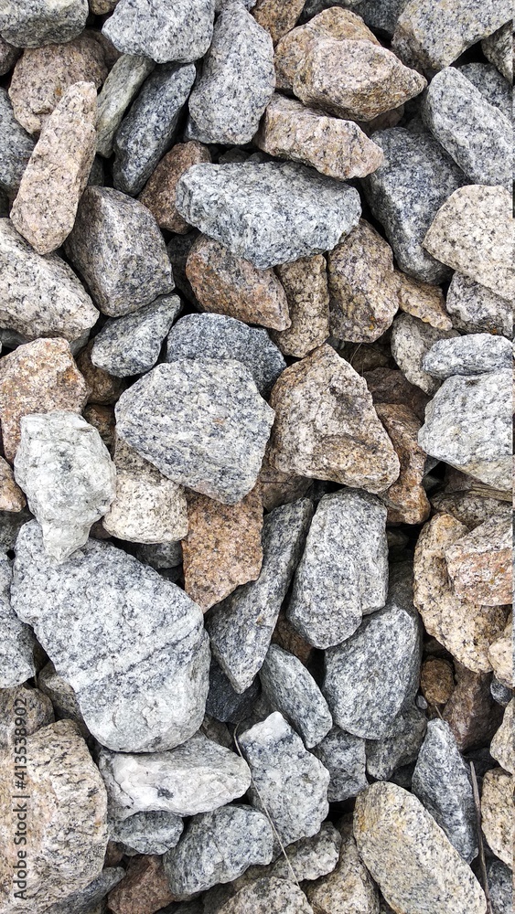Macro photography of crushed stone and gravel of uneven shapes and sizes. Texture background light brown and gray stones with white dots interspersed Macro photography of crushed stone and gravel of uneven shapes and sizes. Texture background light brown and gray stones with white dots interspersed
