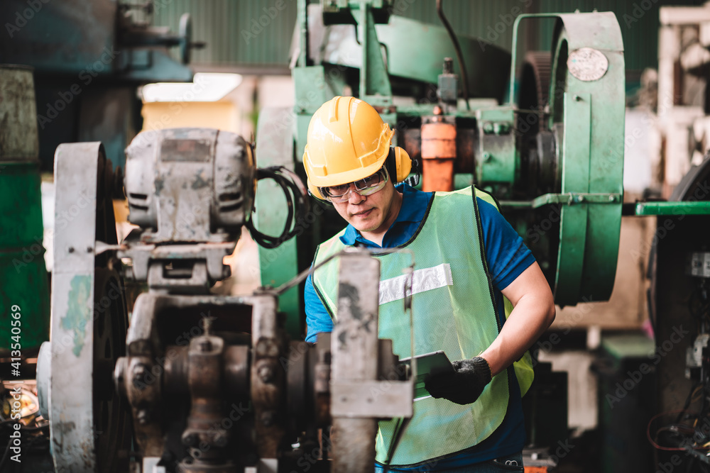 Work at factory.Asian worker man working in safety work wear with yellow helmet using machine.in factory workshop industry meeting professional Work at factory.Asian worker man working in safety work wear with yellow helmet using machine.in factory workshop industry meeting professional