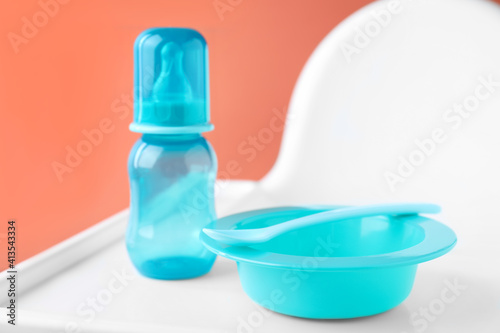 Set of plastic dishware on white feeding table. Serving baby food