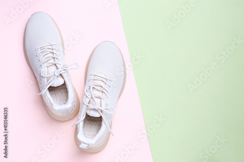 Stylish sporty sneakers on color background, top view. Space for text
