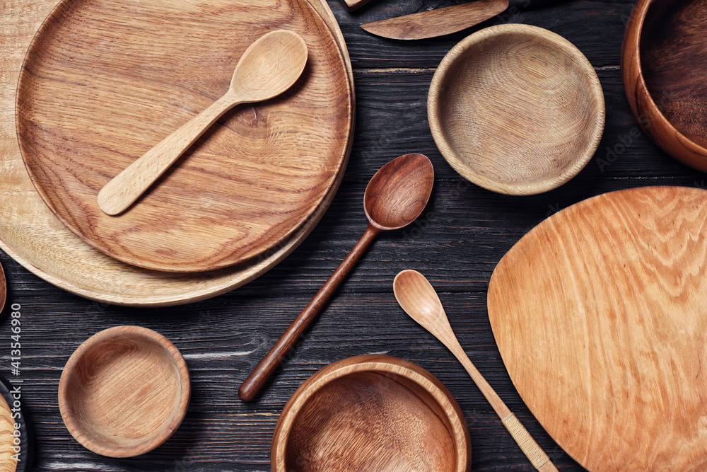 Flat lay composition with wooden dishware on black table