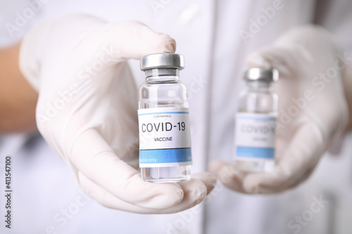 Doctor holding vials with vaccine against Covid-19, closeup