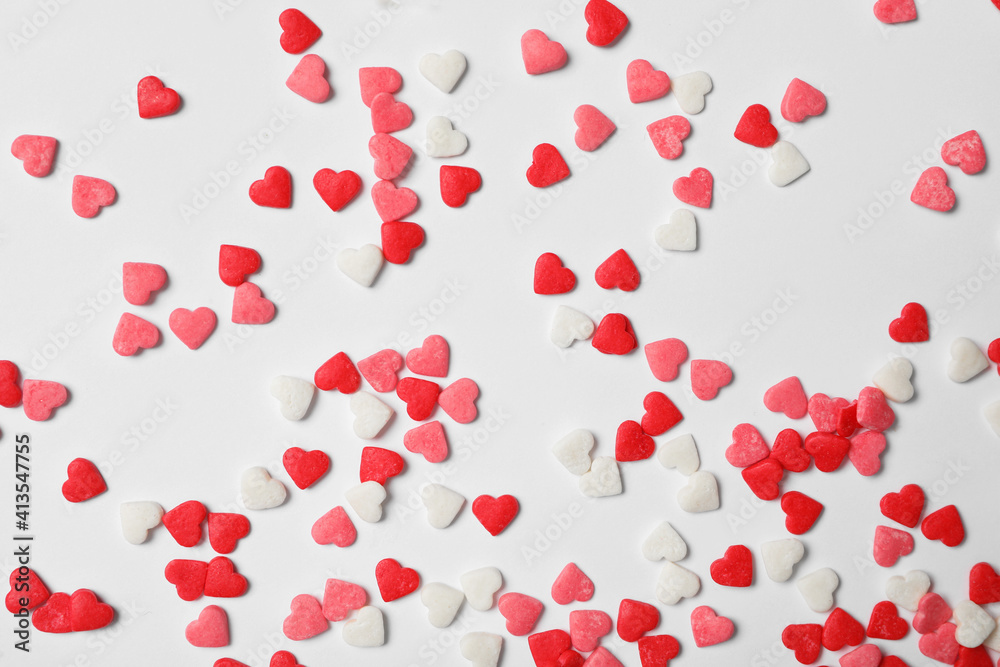 Bright heart shaped sprinkles on white background, flat lay Bright heart shaped sprinkles on white background, flat lay