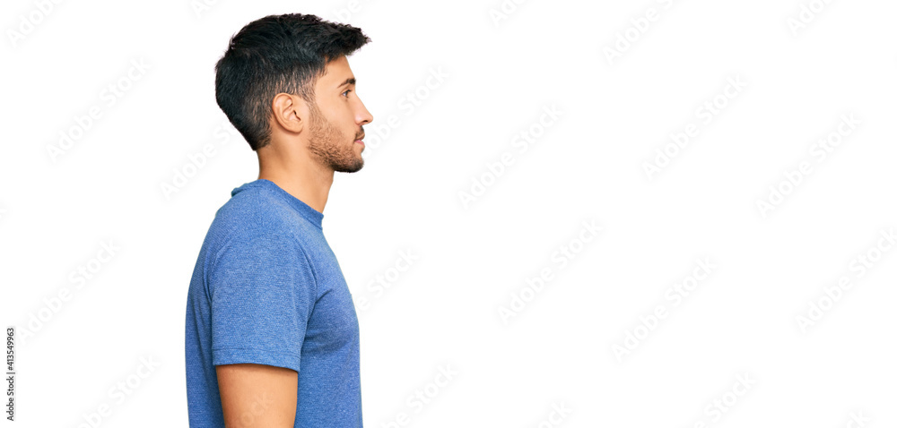 Young handsome man wearing casual clothes looking to side, relax profile pose with natural face with confident smile.