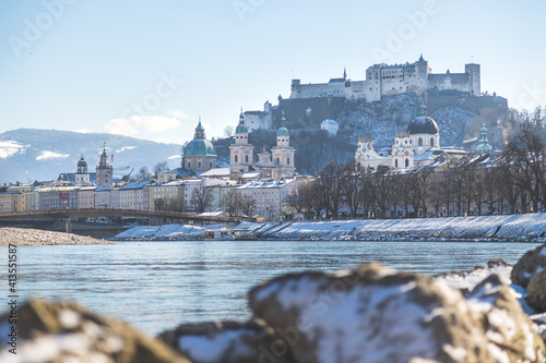 City of Salzburg and snow river bank of Salzach, winter time.
