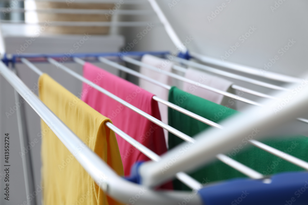 Clean laundry hanging on drying rack indoors, closeup Clean laundry hanging on drying rack indoors, closeup