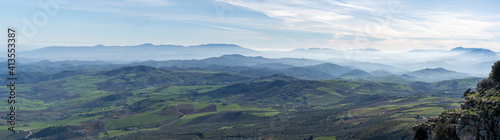 panorama landscape of rolling hills and blue mountain chains