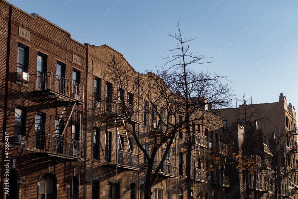 Row of Similar Old Residential Buildings with Fire Escapes in Astoria Queens New York during Autumn