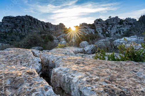 evening light with a sun star in the El Torcal Nature Reserve in Andalusia with strange karst rock formations