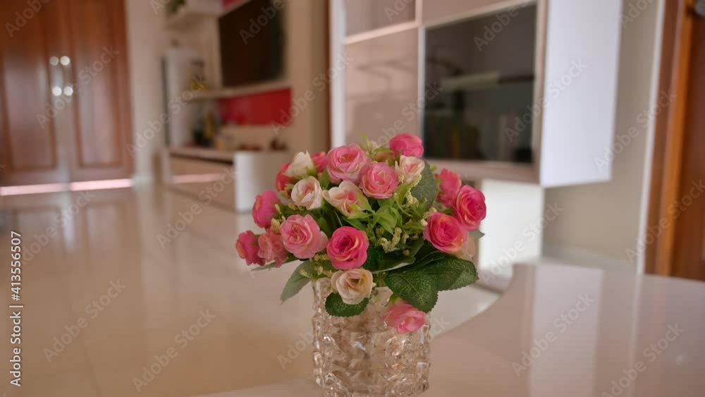 Close up view of pink and white rose indoor decoration on glass vase. Taken from digital camera using parallax trucking movement technique Close up view of pink and white rose indoor decoration on glass vase. Taken from digital camera using parallax trucking movement technique