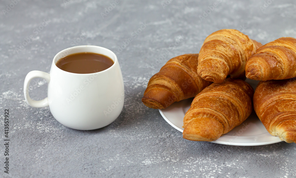 Freshly baked croissants and cup of coffee on rustic stone table Freshly baked croissants and cup of coffee on rustic stone table