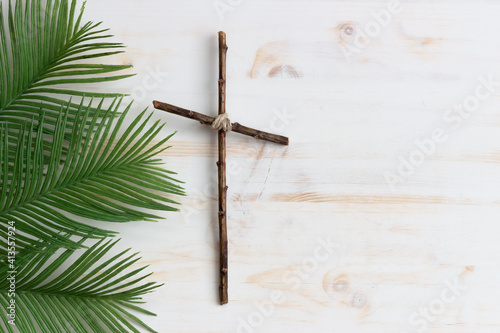 palms and wood cross on white wood background with copy space