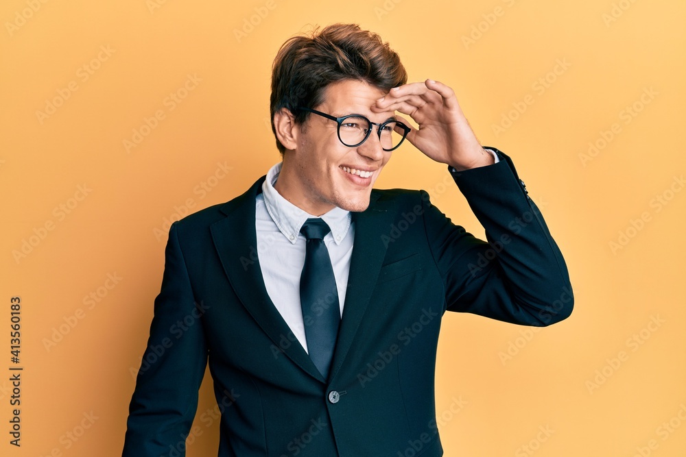 Handsome caucasian man wearing business suit and tie very happy and smiling looking far away with hand over head. searching concept. Handsome caucasian man wearing business suit and tie very happy and smiling looking far away with hand over head. searching concept.