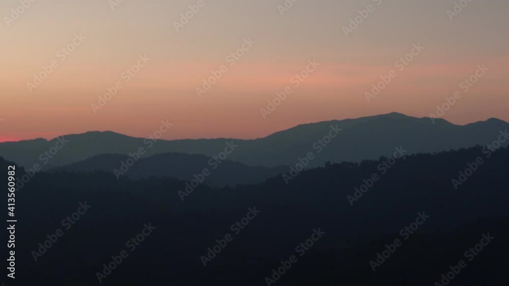pan view of beautiful sunrise and pink sky over mountain pan view of beautiful sunrise and pink sky over mountain
