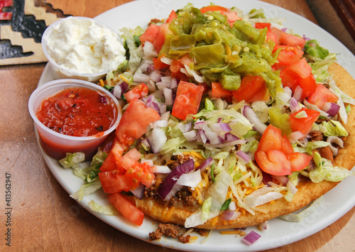large Navajo taco on a plate with sauces