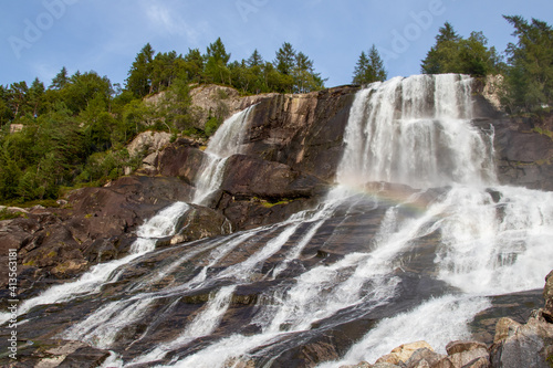 Beautiful Furebergsfossen waterfall in Norway, waterfall on rocky slope near road along the Hardangerfjord fiord