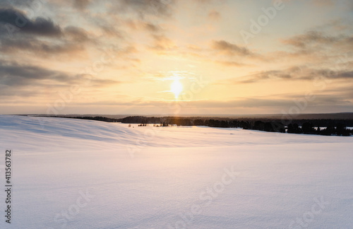 Snowy winter landscape at sunset, smooth snow covered