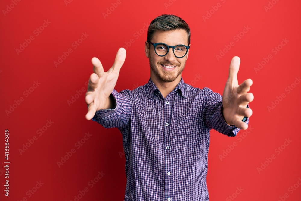 Handsome caucasian man wearing business shirt and glasses looking at the camera smiling with open arms for hug. cheerful expression embracing happiness. Handsome caucasian man wearing business shirt and glasses looking at the camera smiling with open arms for hug. cheerful expression embracing happiness.