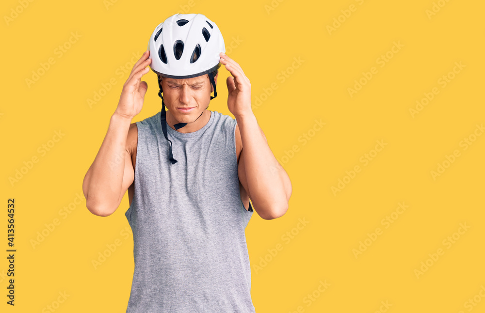 Young handsome man wearing bike helmet with hand on head for pain in head because stress. suffering migraine. Young handsome man wearing bike helmet with hand on head for pain in head because stress. suffering migraine.