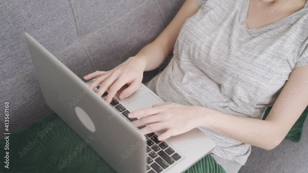 remote working at home office at afternoon, concentrate asian woman sitting on sofa couch in living room, typing computer laptop keyboard for report. close up shot. remote working at home office at afternoon, concentrate asian woman sitting on sofa couch in living room, typing computer laptop keyboard for report. close up shot.