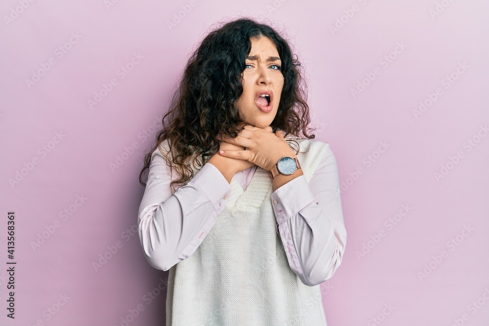 Young brunette woman with curly hair wearing casual clothes shouting suffocate because painful strangle. health problem. asphyxiate and suicide concept. Young brunette woman with curly hair wearing casual clothes shouting suffocate because painful strangle. health problem. asphyxiate and suicide concept.