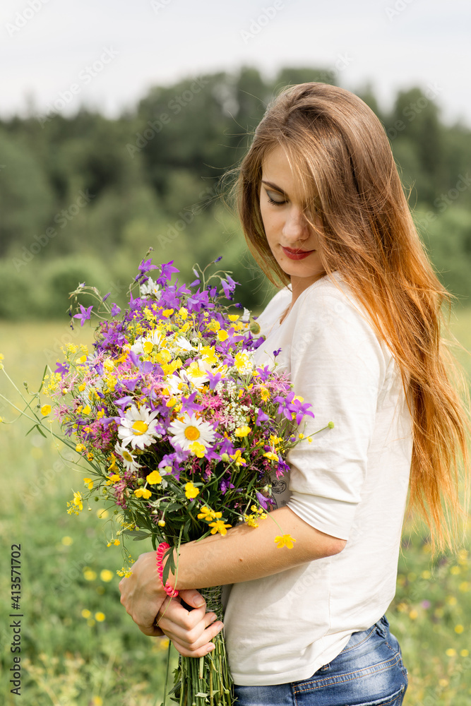 beautiful young girl with long hair in a field with a bouquet of flowers. beautiful young girl with long hair in a field with a bouquet of flowers.