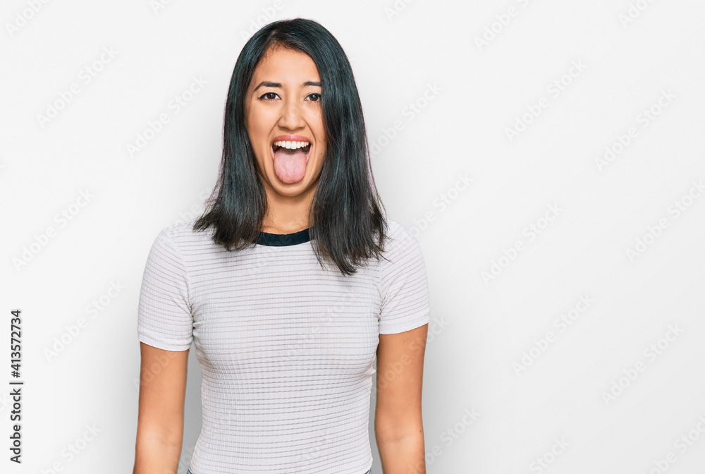 Beautiful asian young woman wearing casual white t shirt sticking tongue out happy with funny expression. emotion concept. Beautiful asian young woman wearing casual white t shirt sticking tongue out happy with funny expression. emotion concept.
