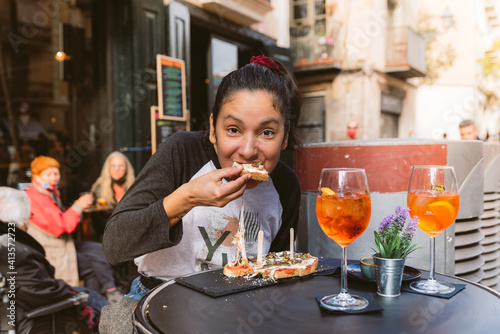 Photography young woman eating bruschetta doing italian happy hour known as aperitivo in bar outdoor terrace