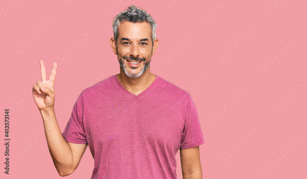 Middle age grey-haired man wearing casual clothes showing and pointing up with fingers number two while smiling confident and happy. Middle age grey-haired man wearing casual clothes showing and pointing up with fingers number two while smiling confident and happy.
