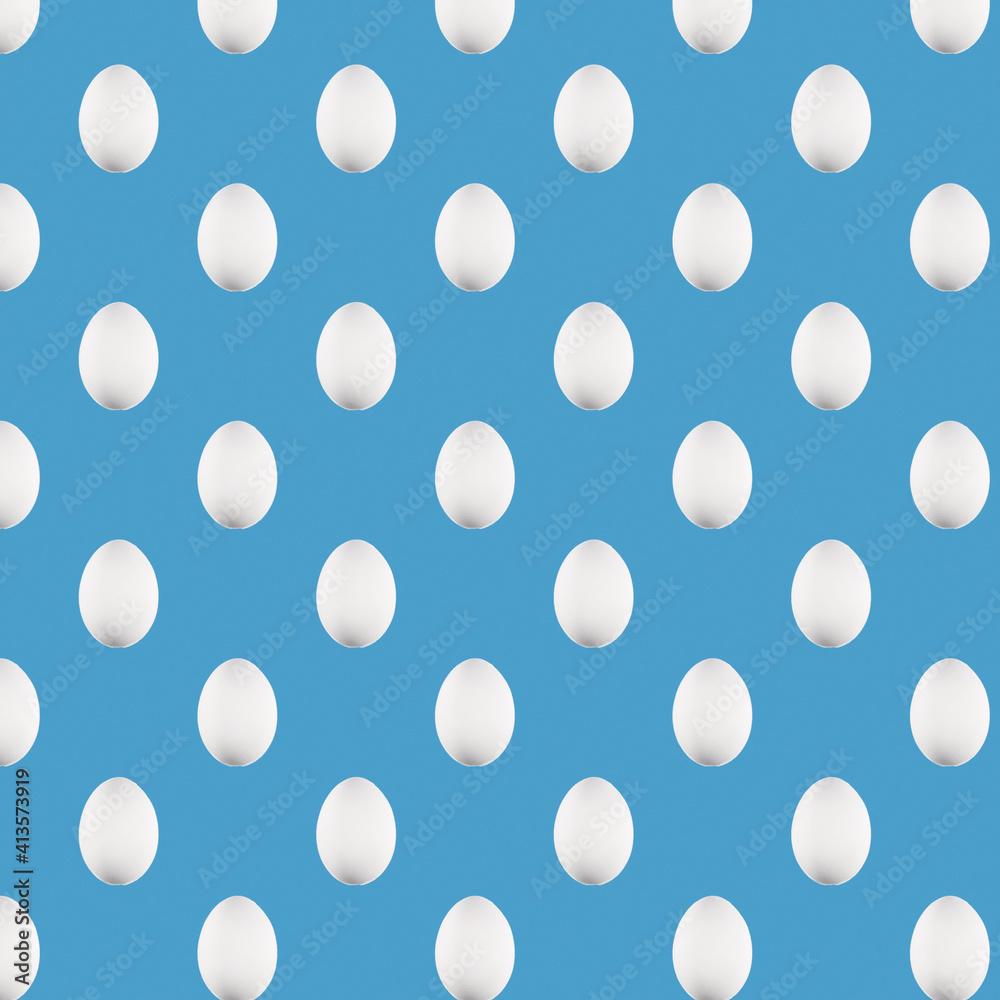 Seamless pattern. A pattern of chicken eggs with a white shell with a hard light on a blue paper background. High-quality photos